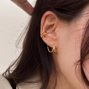 Elegant gold geometric rotating earrings and twisted ear cuff set on female model