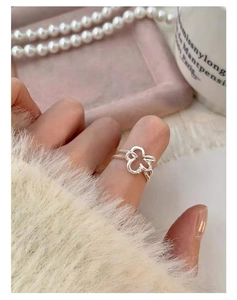 Detailed view of silver five-petal flower ring on finger with soft knit background