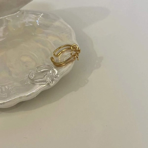 Adjustable 925 sterling silver flower rings in gold and silver set on a shell dish