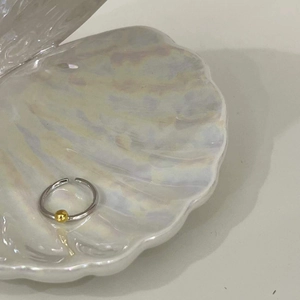 Détail de la bague en argent S925 avec perle dorée dans une coquille de perle