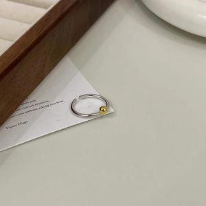 Détail d'une bague ajustable en argent 925 avec une petite perle dorée polie