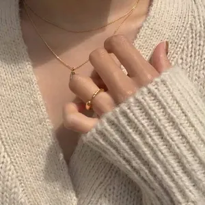 Ensemble bague et collier cœur en argent 925 plaqué or sur un fond en maille douce