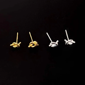 Macro detail of S925 hallmark on minimalist knot stud earrings in silver and gold