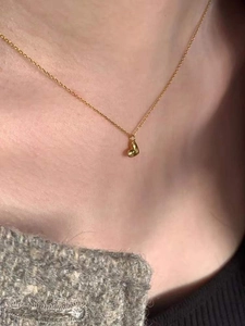 Makroaufnahme einer 3D-Gold-Herz-Anhänger-Halskette mit feiner Kettengliederung