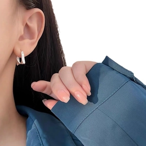 Minimalist S925 sterling silver geometric U-shaped hoop earrings worn by a model