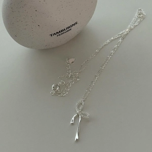 Elegante collana in argento sterling S925 con ciondolo a fiocco scintillante su sfondo grigio