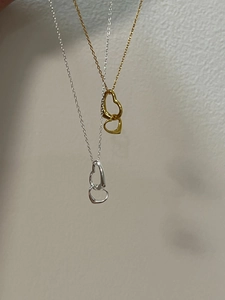 Detailansicht der verschlungenen Herzanhänger in Gold und Silber mit O-Ketten