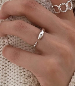 Gros plan d'une bague ouverte en argent 925 minimaliste avec extrémités en forme de goutte