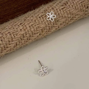 Macro view of sterling silver sunflower studs with sparkling zircon petals and ear pin structure