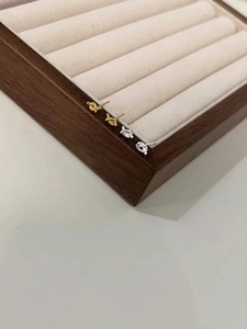 Detail view of gold and silver minimalist knot stud earrings on a velvet tray