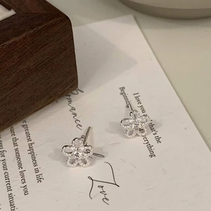 Macro view of sunflower stud earrings with sparkling zircons on romantic poetry card