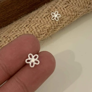 Detailed close-up of small 925 sterling silver sun flower stud earrings with zircon stones