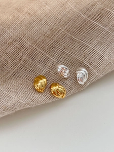 Vue détaillée des boucles d'oreilles torsadées en métal poli doré et argenté élégant