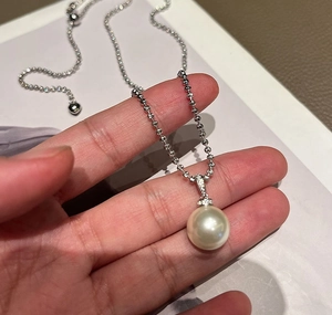 Close-up of elegant 925 silver ball chain necklace with white pearl and pavé crystals