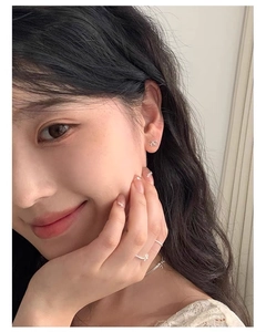 Close-up of model wearing tiny 925 sterling silver bow earrings and matching open ring