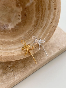 Détails de boucles d'oreilles nœuds dorées et argentées avec fini métal poli sur pierre