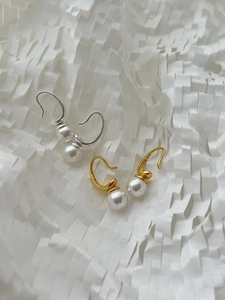 Macro shot of S925 sterling silver hooks with lustrous round pearls in gold and silver