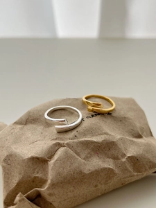 Close-up of minimalist gold and silver 925 sterling silver wrap rings on brown paper