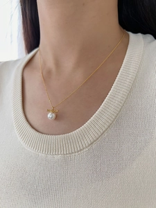 Detail shot of a S925 silver twist pendant necklace with a round white pearl on a model