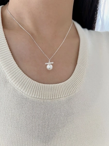 Detailed view of S925 sterling silver twist necklace with white pearl on model neck