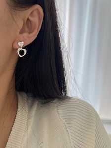 Detailed close-up of 925 sterling silver hollow heart earrings worn by a model