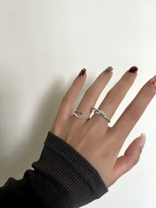 Détail d'une bague nœud en argent S925 et d'un anneau ajustable sur le doigt d'un mannequin