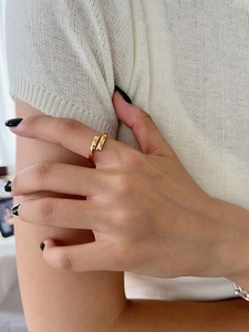 Close-up of minimalist double-layer gold open ring worn on finger with polished finish