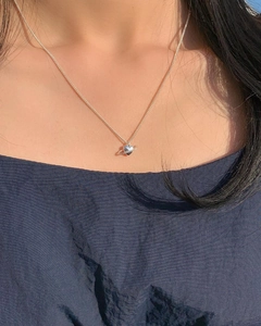 Close-up of S925 silver heart saturn pendant necklace worn on a woman's collarbone