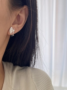 Detail of s925 silver fan earring with white pearl and tassel worn by a model