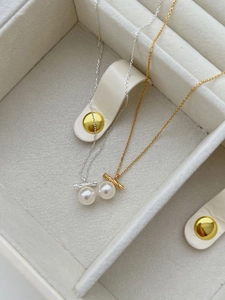 Close-up of S925 sterling silver twist necklaces with lustrous white pearls in a jewelry box