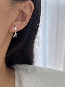 Close-up of S925 silver double bow ribbon earrings shown on model for size and drop length