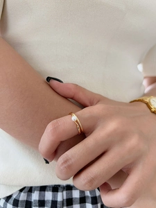 Detailed shot of a 925 silver overlapping gold-tone ring with a lustrous white pearl