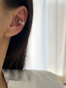 Close-up of 925 sterling silver bow ear cuff earring worn on a female model ear