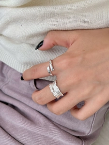 Close-up of S925 sterling silver rings with smooth wrap and lava texture on model