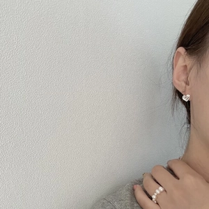 Eleganti orecchini a lobo a cuore in argento 925 e anello di perle indossati da modella
