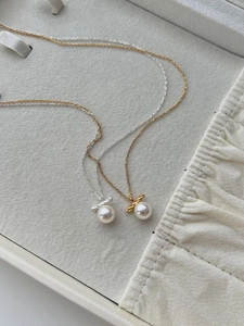 Macro shot of S925 silver twist knot pearl necklaces in gold and silver finish