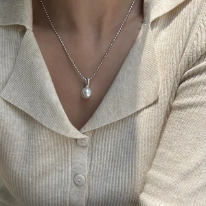 Elegant white pearl pendant necklace with S925 silver ball chain on a knitted sweater