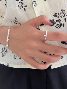 Detail of 925 sterling silver twist cuff bracelet and sphere open ring set for women