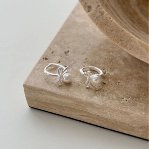 Elegant 925 sterling silver bow earrings with round white pearls on marble surface