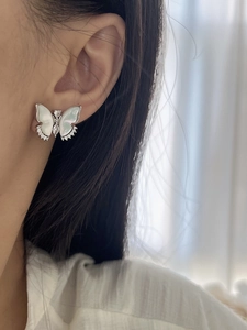 Vue macro de boucles d'oreilles papillon en argent 925 avec nacre blanche et zircone