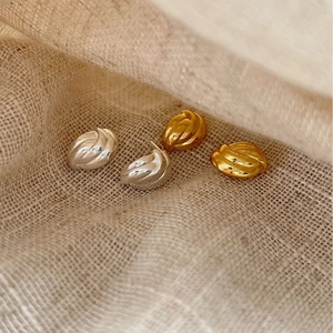 Ensemble de boucles d'oreilles torsadées en or et argent sur fond de toile de jute