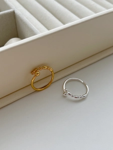 Detailed view of silver and gold beaded rings with round ball accents on a jewelry tray