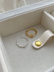 Detailed view of polished gold and silver stackable rings with elegant bead design