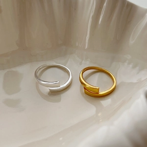 Minimalist geometric 925 silver and gold open rings set on a ceramic tray
