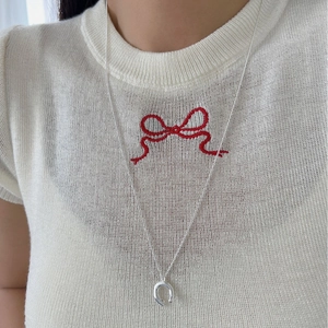 Elegant silver horseshoe pendant necklace on model wearing white knit top