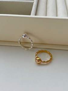 Detail of beaded gold and silver rings with star-engraved spheres and small crystals