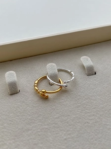 Detail view of gold and silver beaded 925 sterling silver rings in a jewelry display box