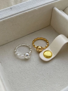 Detailed close-up of gold and silver ball rings with star engravings on velvet