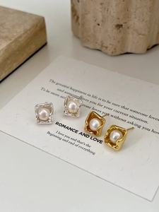 Detail of minimalist irregular square frame pearl earrings in gold and silver finish