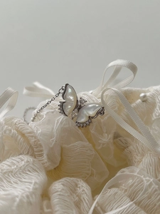 Macro d'un collier pendentif papillon avec nacre et accents en zircons brillants